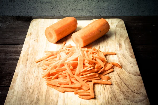 Sliced carrots on a wooden cutting board. Toned — Stock Photo, Image