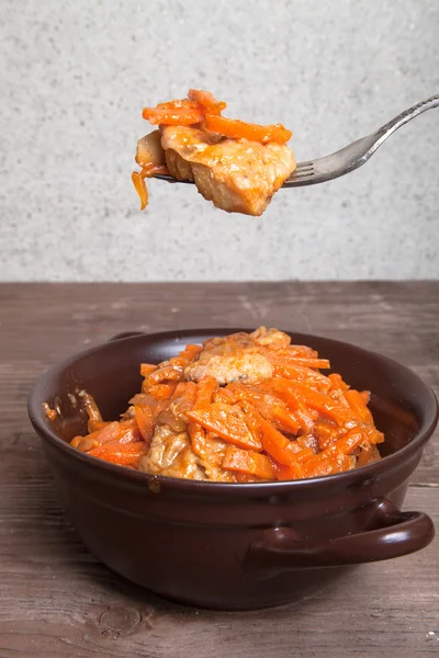 Poisson mariné aux carottes dans un bol en céramique brune et sur le f — Photo