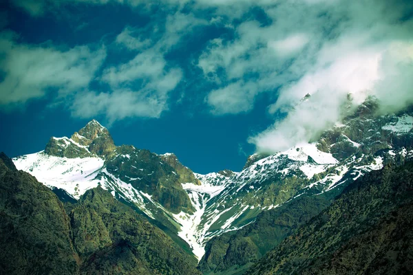 Wolken über den schneebedeckten Gipfeln der Felsen. Landschaft. gemildert — Stockfoto