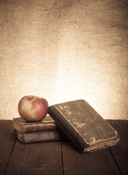 Nature morte avec pomme et une pile de vieux livres sur une vieille languette en bois — Photo