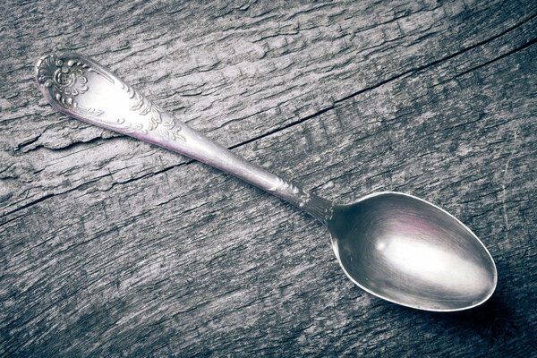 Retro spoon on the old wooden table. Toned