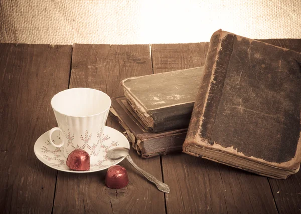 Tasse Kaffee, Shokolad und Stapel alter Bücher auf dem alten Holz — Stockfoto