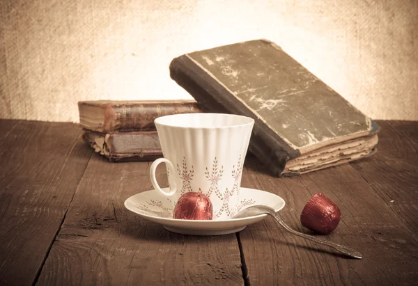 Kopje koffie, shokolad en stapel oude boeken op de oude houten — Stockfoto