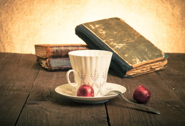 Taza de café, shokolad y pila de libros antiguos sobre la madera vieja —  Fotos de Stock