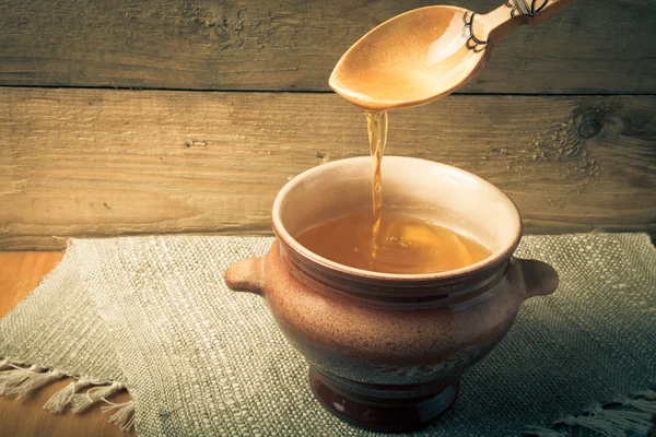 Clay pot with ghee and spoon on linen napkin. Rustic still life. — Stock Photo, Image