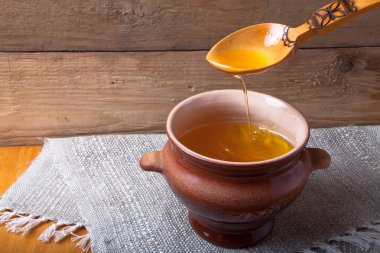 Ghee ve kaşık keten peçete ile toprak kap. Rustik natürmort.