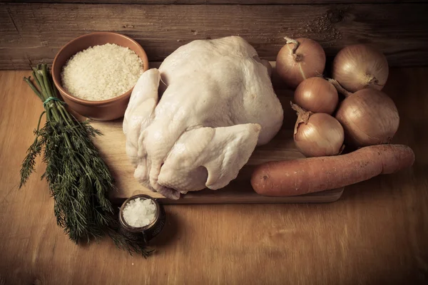 Pollo crudo intero, cipolla, carota, aneto, riso, sale su bac di legno — Foto Stock