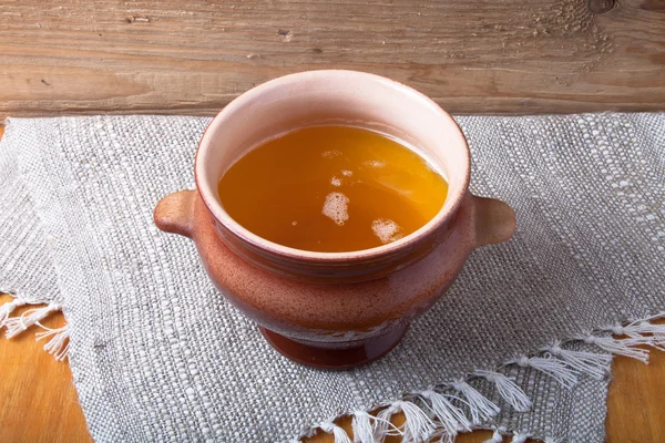 Clay pot with ghee on linen napkin. Rustic still life. Wooden ba — Stock Photo, Image