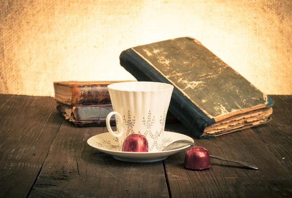 Taza de café, shokolad y pila de libros antiguos sobre la madera vieja —  Fotos de Stock