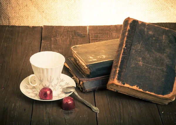 Kopje koffie, shokolad en stapel oude boeken op de oude houten — Stockfoto