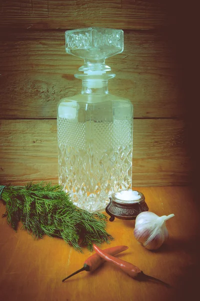 Carved decanter of vodka and ingredients for tinctures. Tinted. — Stock Photo, Image