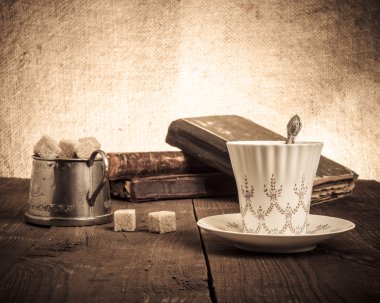 Fincan kahve, şekerlik ve eski kitap eski odun yığını