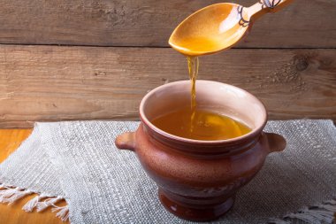 Ghee ve kaşık keten peçete ile toprak kap. Rustik natürmort.