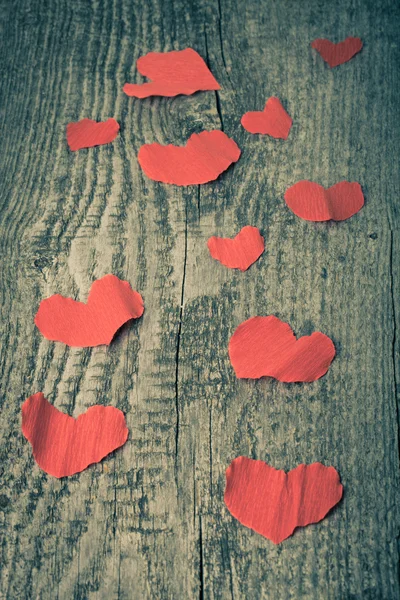 Many Valentine hearts on the old wooden table. Toned. — Stock Photo, Image