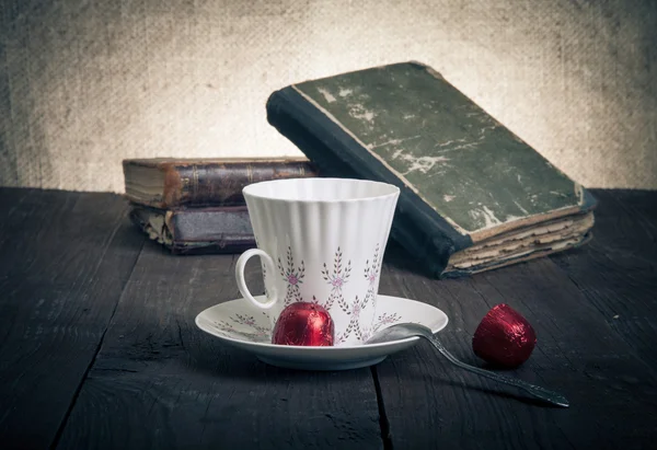 Tasse Kaffee, Shokolad und Stapel alter Bücher auf dem alten Holz — Stockfoto