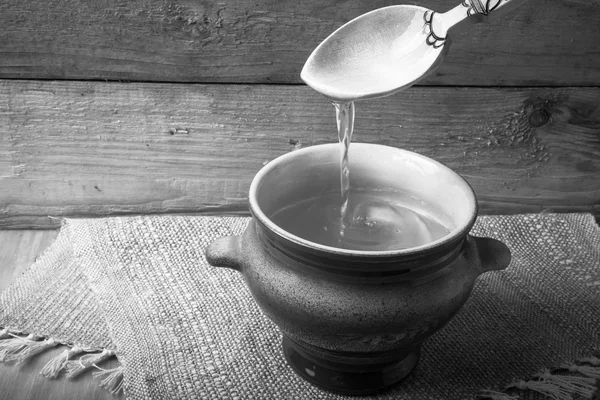 Clay pot with ghee and spoon on linen napkin. Rustic still life. — Stock Photo, Image