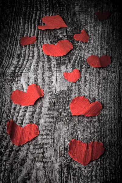 Many Valentine hearts on the old wooden table. Toned. — Stock Photo, Image