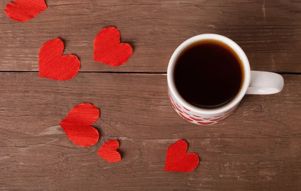 Corazones de San Valentín y taza de té en la vieja mesa de madera . — Foto de Stock