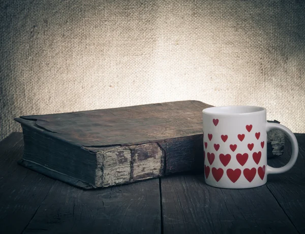 Tazza di caffè, vecchi libri sul vecchio tavolo di legno . — Foto Stock