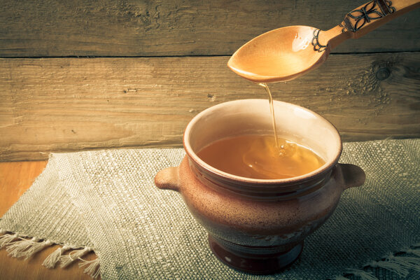 Выложить горшок с гхи и ложкой на льняную салфетку. Сельский натюрморт
.