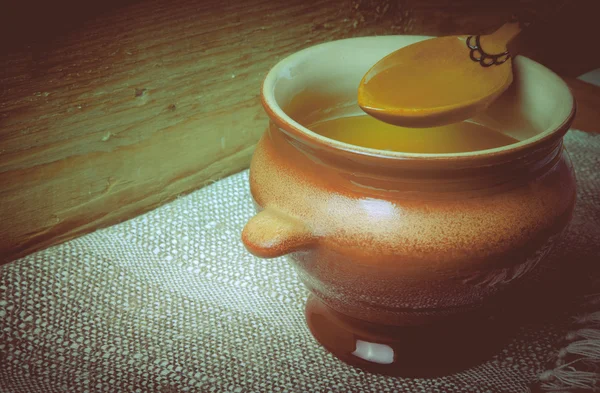 Clay pot with ghee and spoon on linen napkin. Rustic still life. — Stock Photo, Image