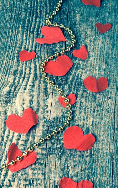 Πολλές καρδιές του Αγίου Βαλεντίνου και λαμπρές χάντρες στο παλιό ξύλινο τραπέζι. T — Φωτογραφία Αρχείου