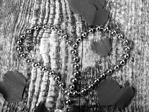 Πολλές καρδιές του Αγίου Βαλεντίνου και λαμπρές χάντρες στο παλιό ξύλινο τραπέζι. T — Φωτογραφία Αρχείου