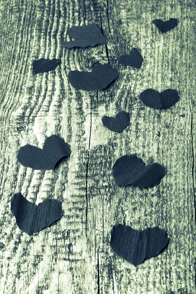 Muchos corazones de San Valentín en la vieja mesa de madera. Tonificado . — Foto de Stock