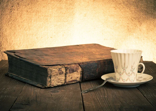 Šálek kávy, staré knihy na starý dřevěný stůl. — Stock fotografie