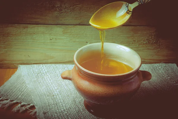 Pot d'argile avec ghee et cuillère sur serviette en lin. Nature morte rustique . — Photo