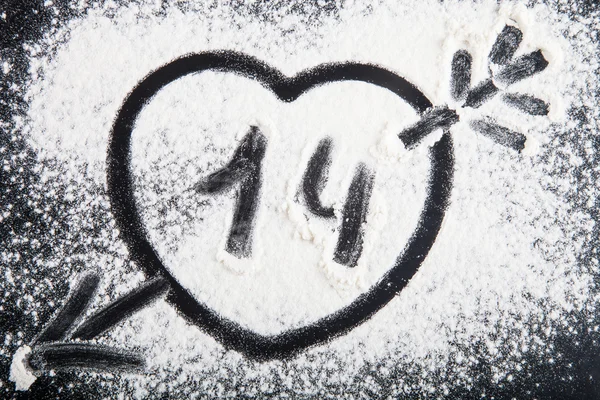 Forma de coração com seta desenhada sobre a farinha em um backgrou preto — Fotografia de Stock