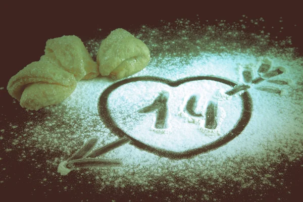Desenhar um coração com uma seta na farinha e biscoitos para feliz — Fotografia de Stock