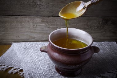 Ghee ve kaşık keten peçete ile toprak kap. Rustik natürmort.