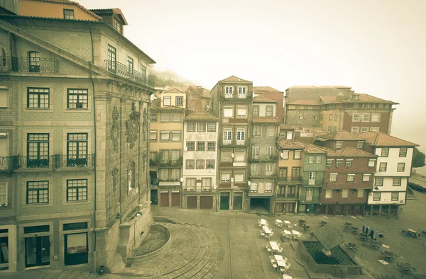 Casas antigas e um café ao ar livre em um aterro de rio enevoado. Porto — Fotografia de Stock