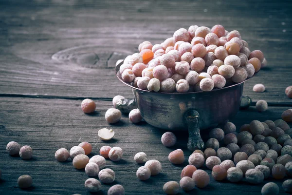 Cuenco de cobre con guisantes secos en mesa de madera vieja . — Foto de Stock