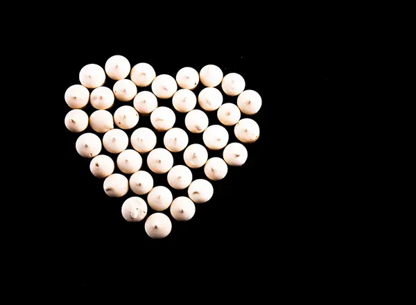 Piccoli biscotti posati a forma di cuore su sfondo nero — Foto Stock