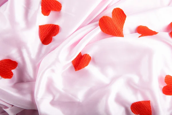 Pink silk with red paper hearts — Stock Photo, Image