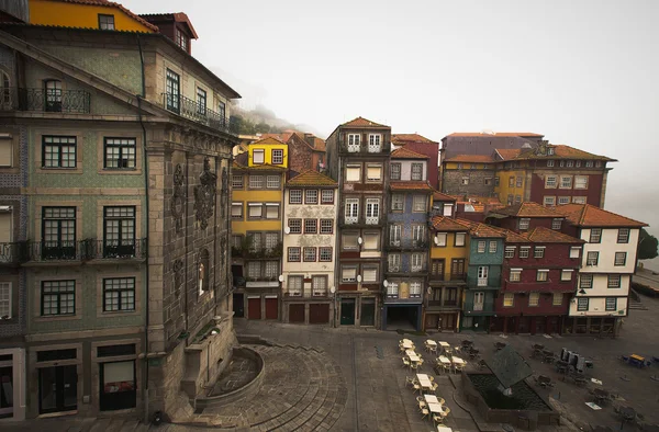 Casas antigas e um café ao ar livre em um aterro de rio enevoado. Porto — Fotografia de Stock