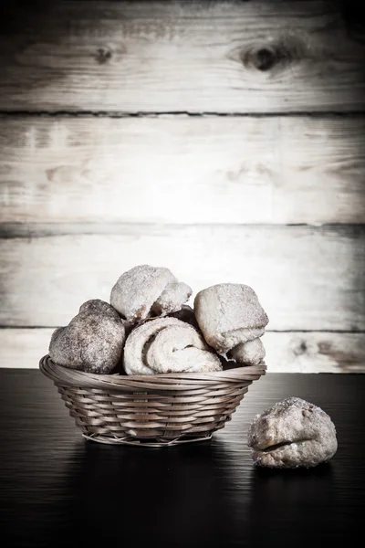 Basket of cookie on a black table against old wooden background. — Stock Photo, Image