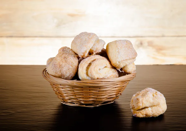 Basket of cookie on a black table against old wooden background. — Stock Photo, Image