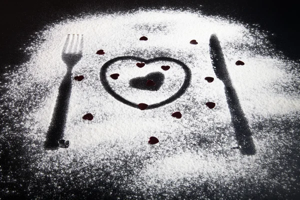 Silhuetas de garfo, faca e corações na farinha em uma ba preta — Fotografia de Stock