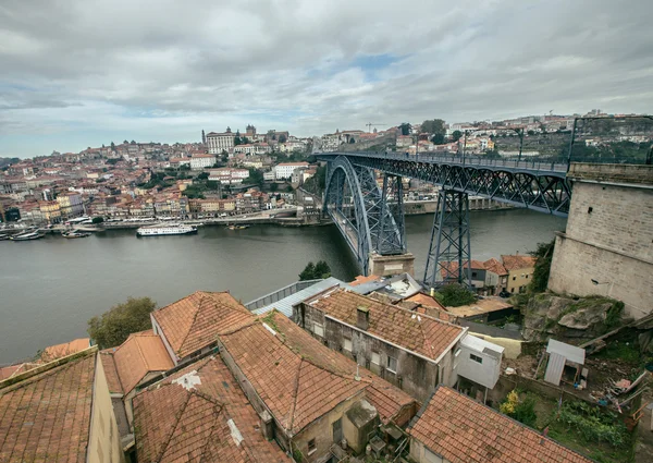 Telhados de azulejos vermelhos, ponte metálica, casas antigas e o rio Douro em — Fotografia de Stock