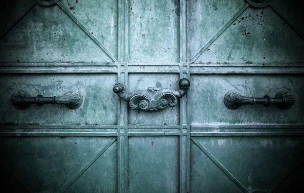 The old metal door with curly handles. Background. Toned — Stock Photo, Image