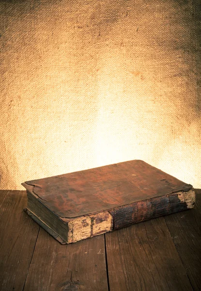 Ancient book on the old wooden table. Toned — Stock Photo, Image