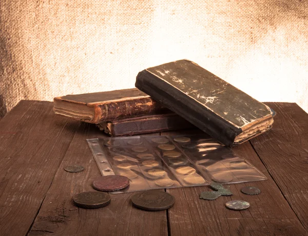 Livros e moedas vintage na velha mesa de madeira — Fotografia de Stock