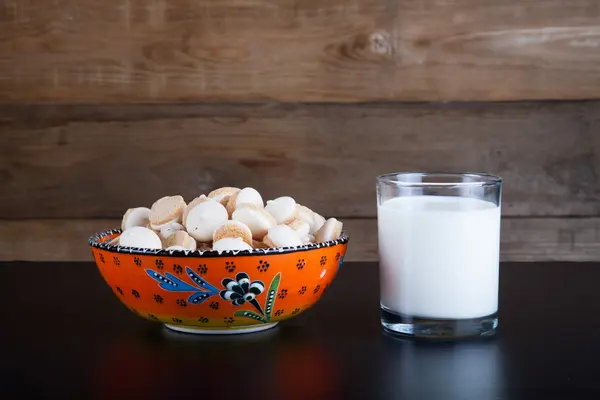 Small cookies in the Turkish bowl and glass of milk on a black t — Stock Photo, Image