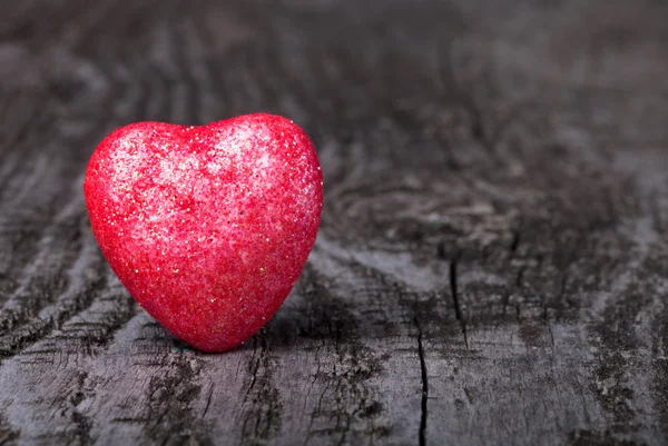 Coeur rouge brillant sur un vieux fond en bois — Photo