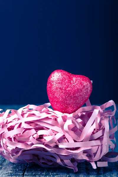 Corazón rojo brillante con una paja de papel sobre un fondo negro. Tonificado — Foto de Stock