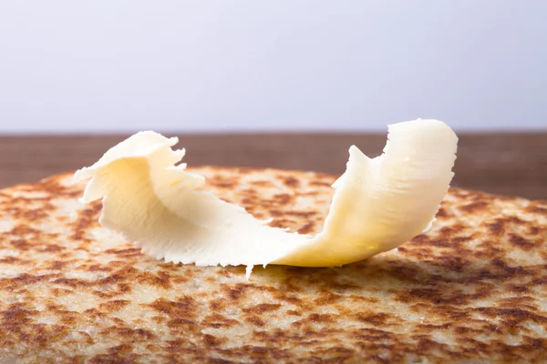 El pedazo pequeño de la mantequilla en la pila de los crepes rusos - blini — Foto de Stock