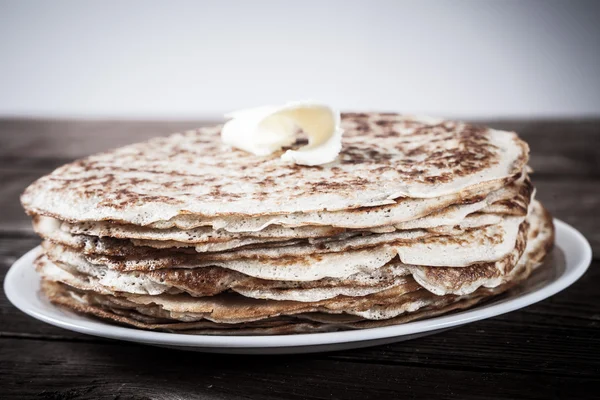 Yığın Rusça krep - blini bir wite üzerinde eski ahşap plaka — Stok fotoğraf